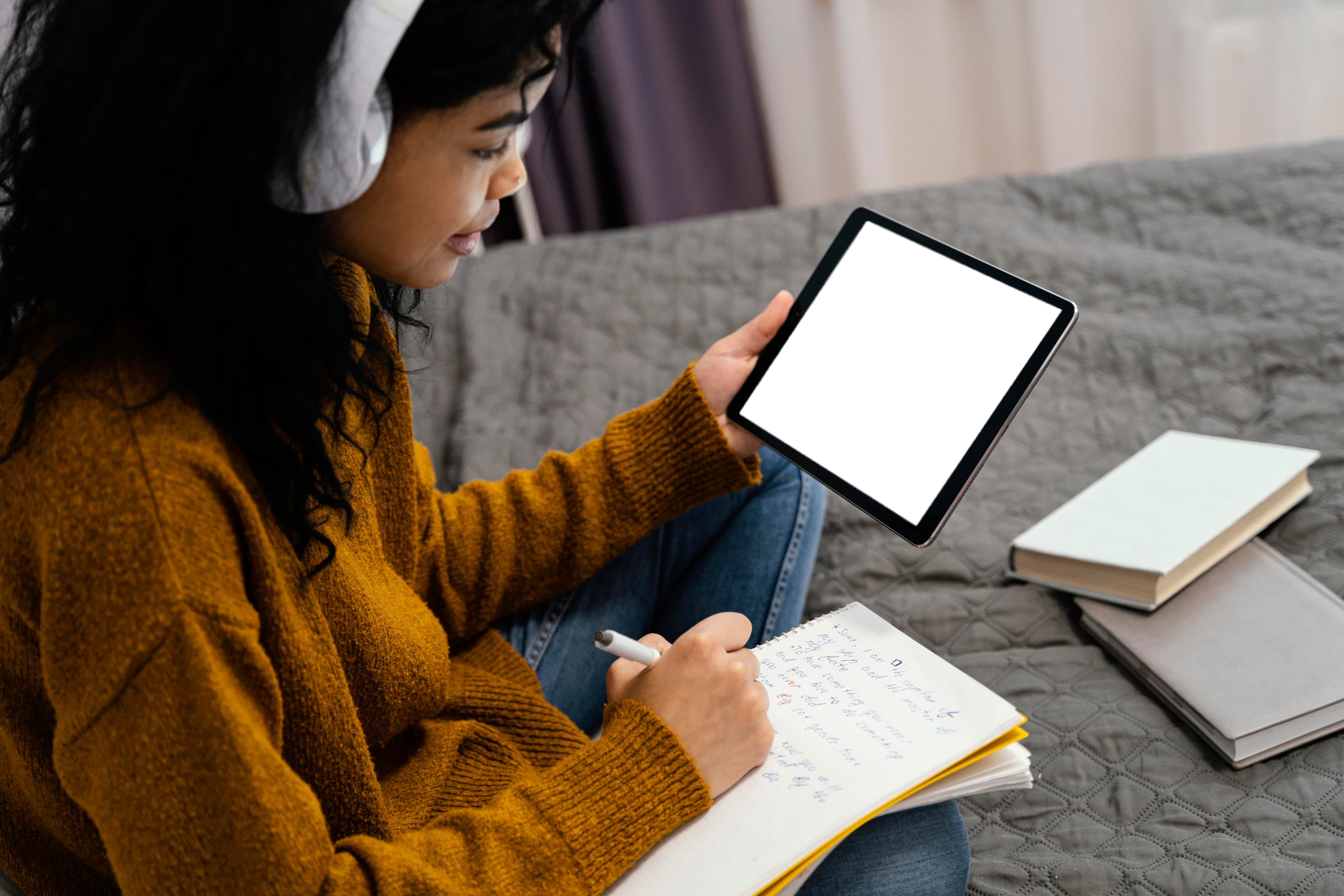 Student studying with a tablet and notebook