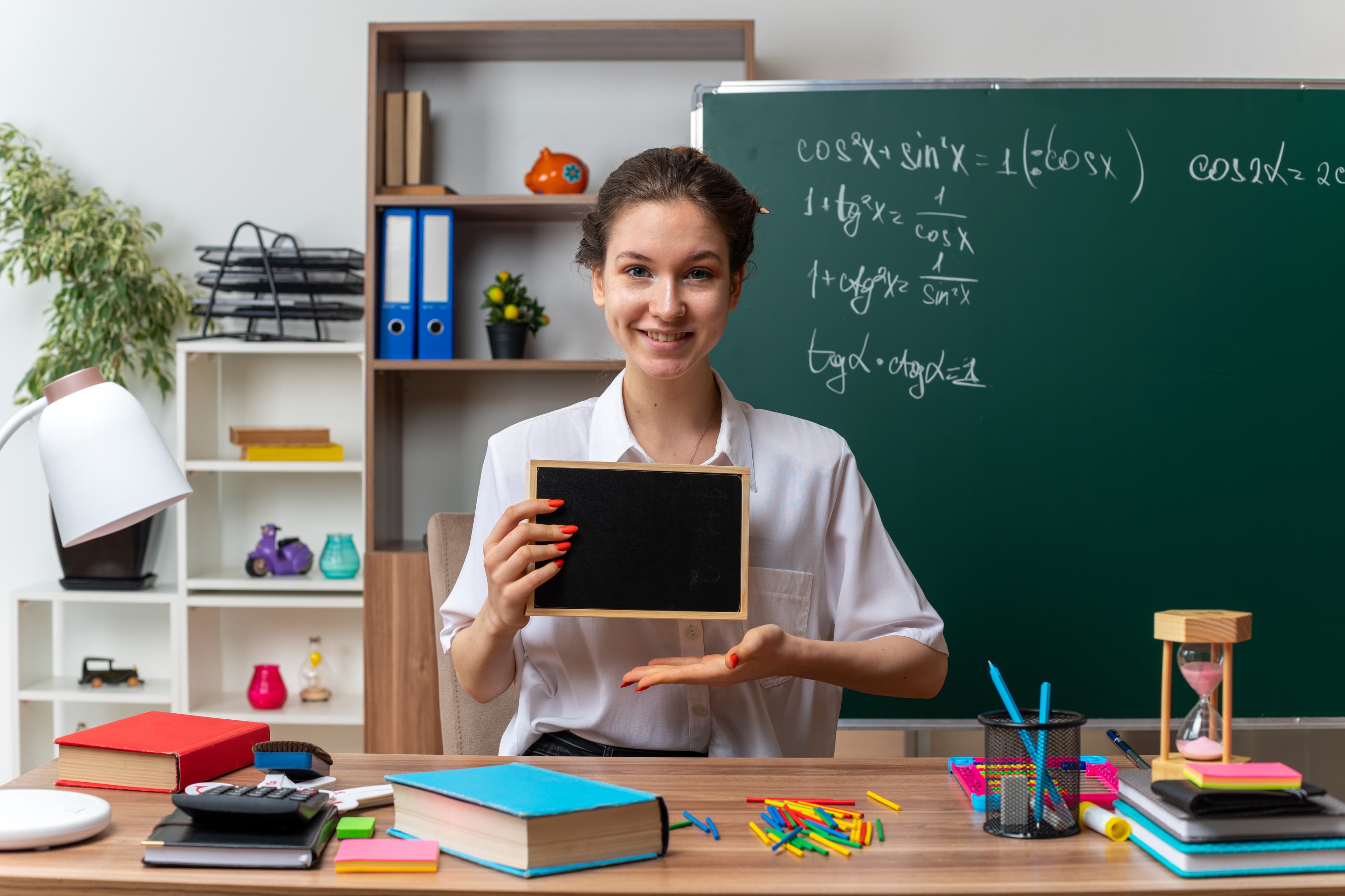 Teacher presenting with a tablet at a blackboard